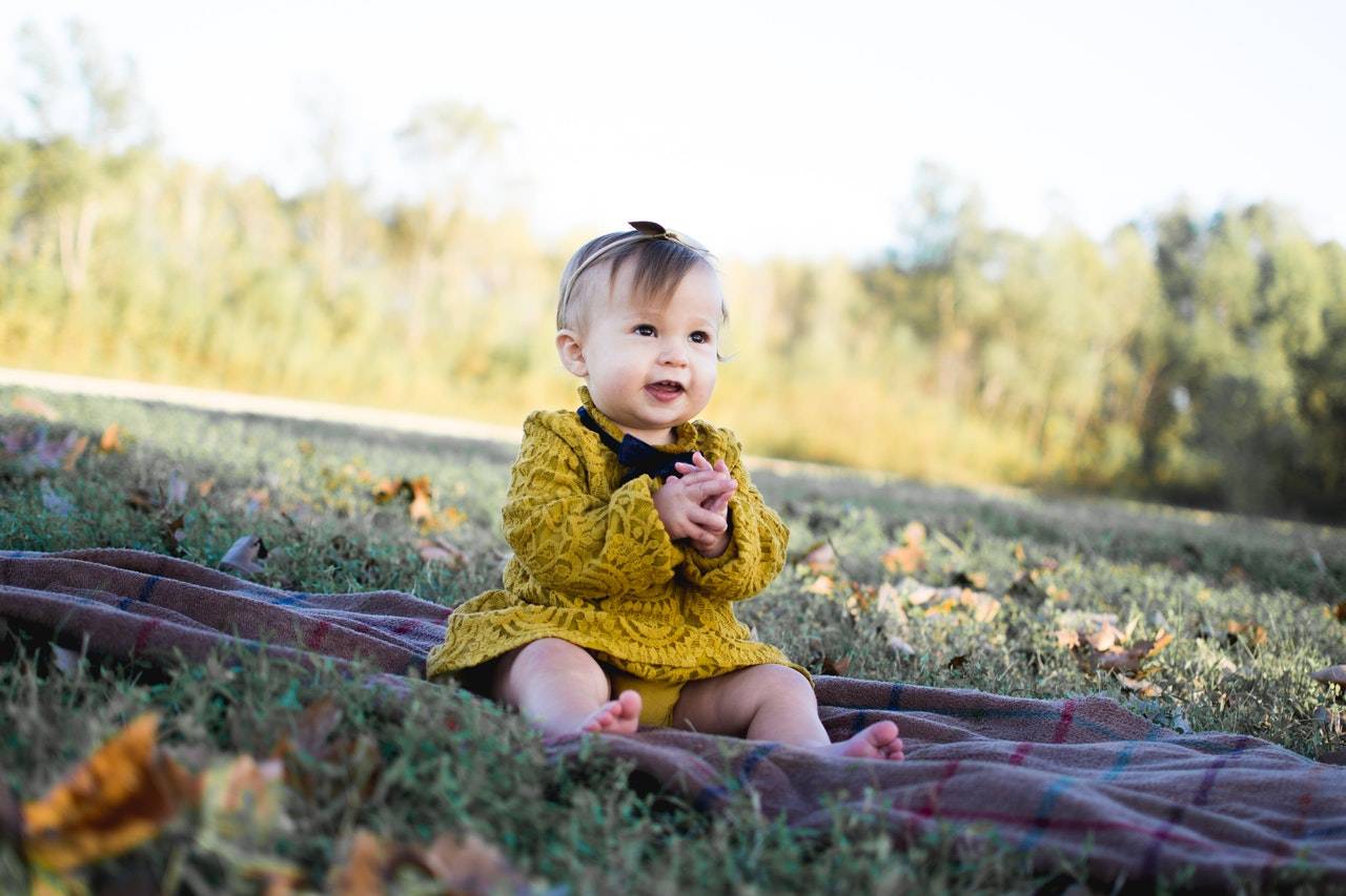 a baby on a field - taking care of a new born baby by darren yaw wife